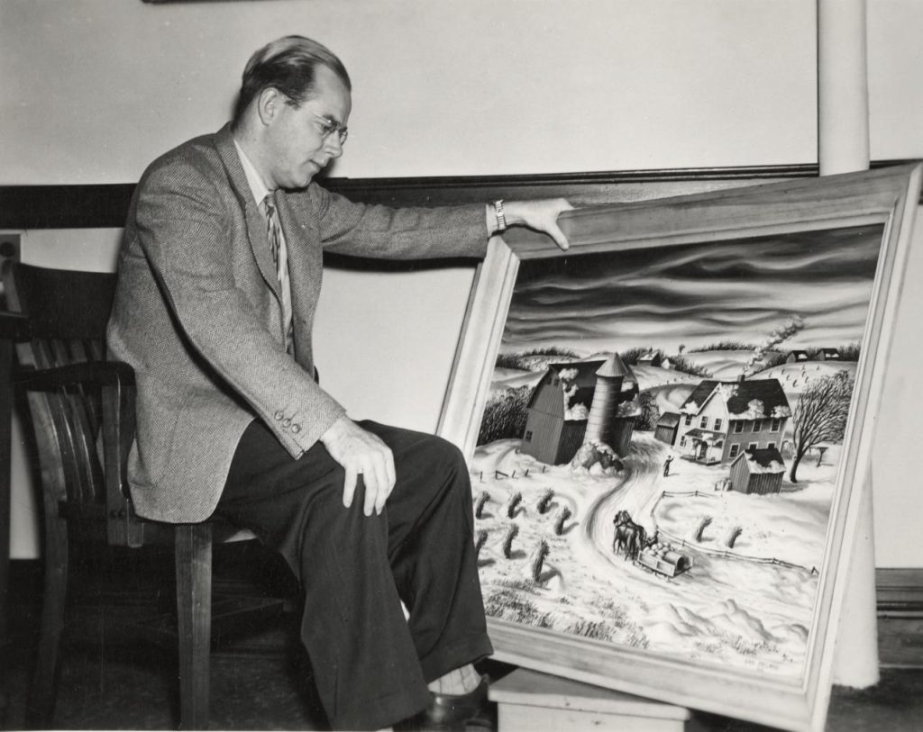 UW faculty and artist in residence John Steuart Curray poses with one of his paintings of a rural farmstead. Image from the University of Wisconsin–Madison Archives